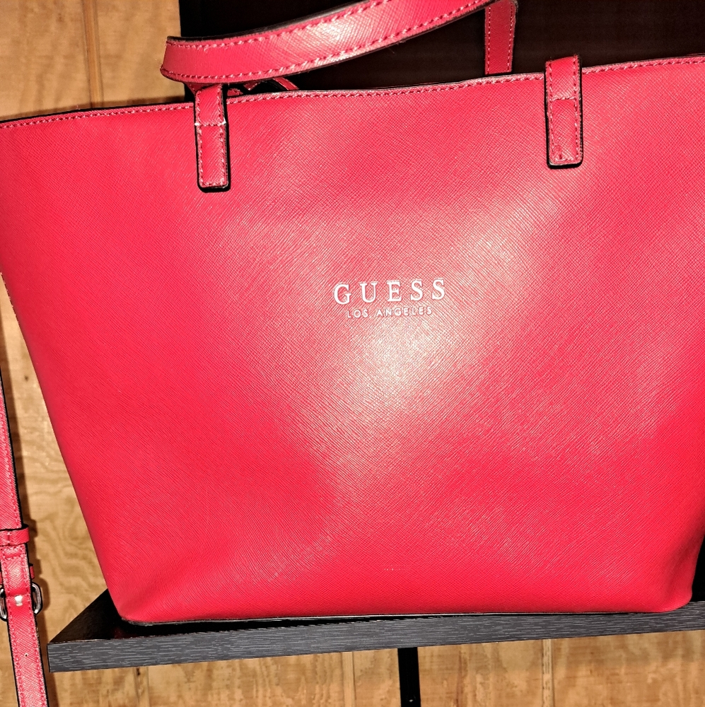 Guess purse ,hand held or over the shoulder,comes with the shoulder strap.